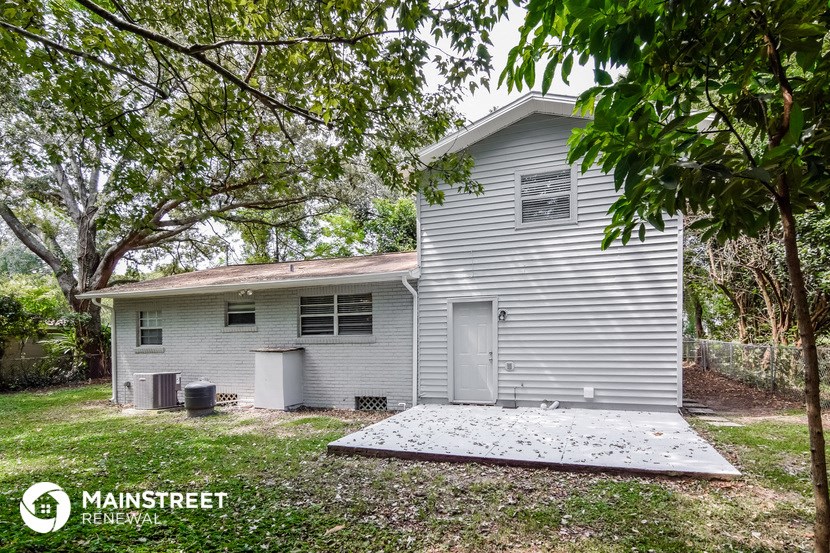 a small white house with a yard and trees