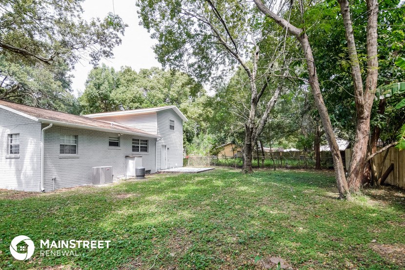 a white house with a yard and trees