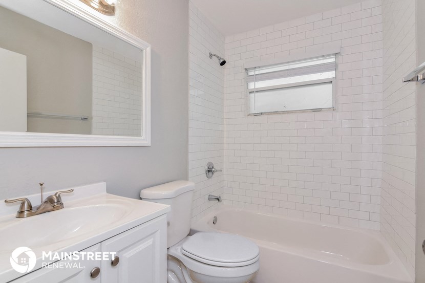 a white bathroom with a tub and a toilet and a sink