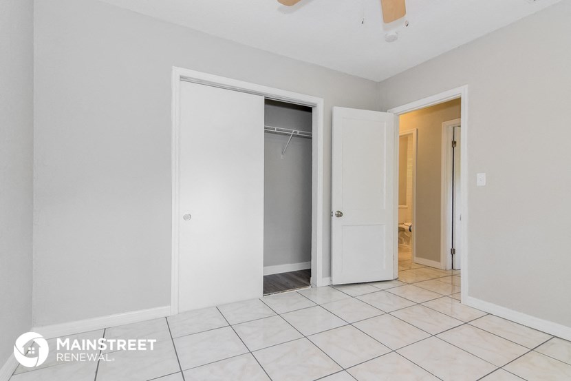 a bathroom with a closet and a tiled floor