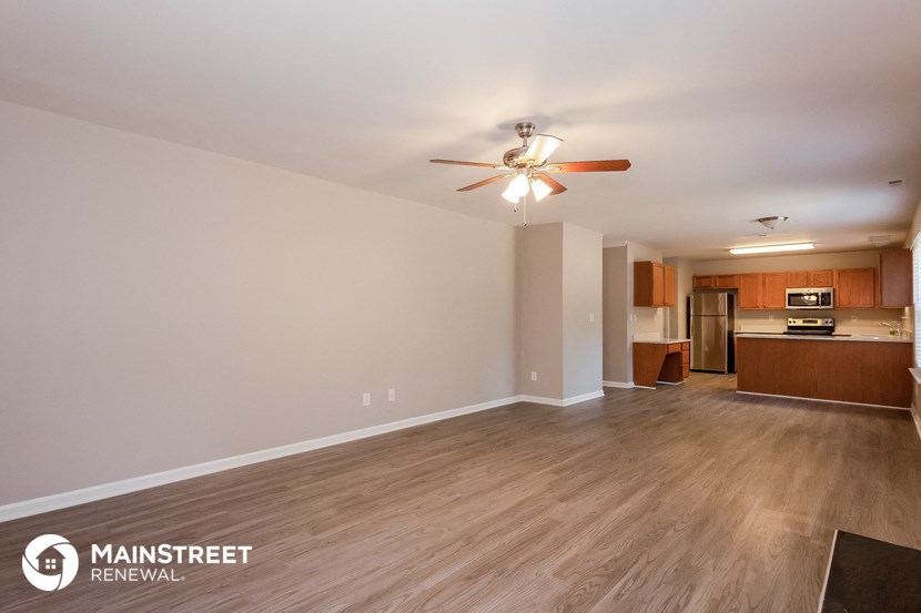 a living room with wood flooring and a ceiling fan