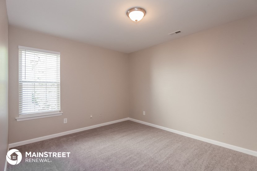 the upstairs bedroom with carpet and window