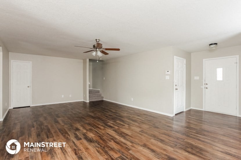 a living room with a ceiling fan and wood floors