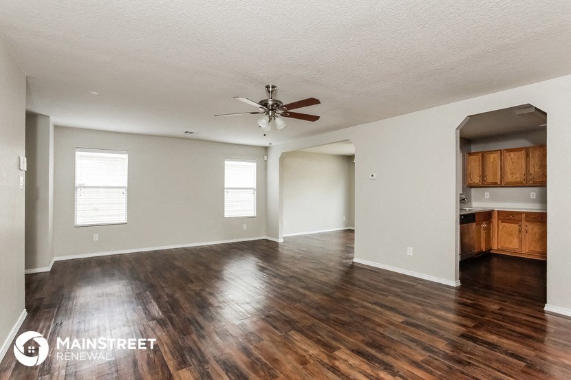 the living room and dining room with hardwood flooring and a ceiling fan
