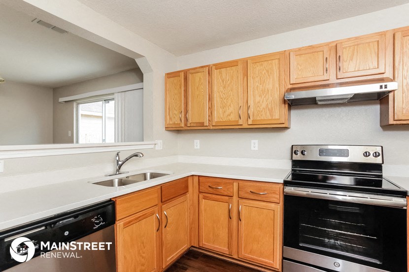 a kitchen with wooden cabinets and a stove and a sink