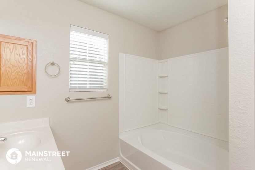 a bathroom with a tub and a sink and a window