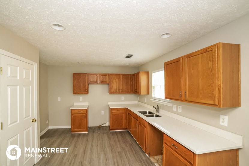 a kitchen with wooden cabinets and a white counter top