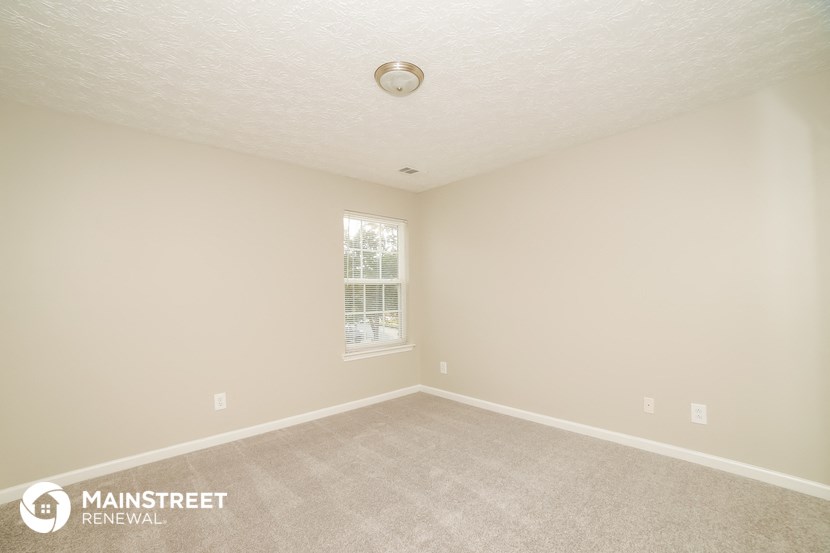 a bedroom with a carpeted floor and a window