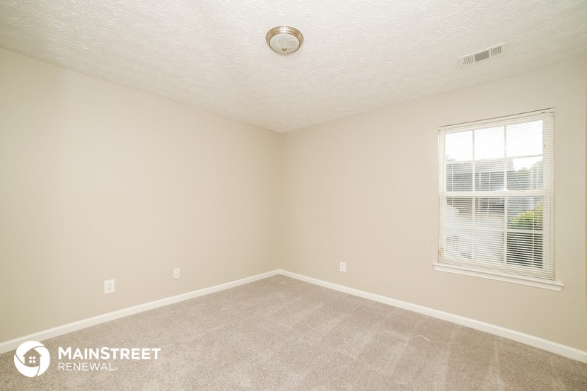the upstairs bedroom with carpet and window
