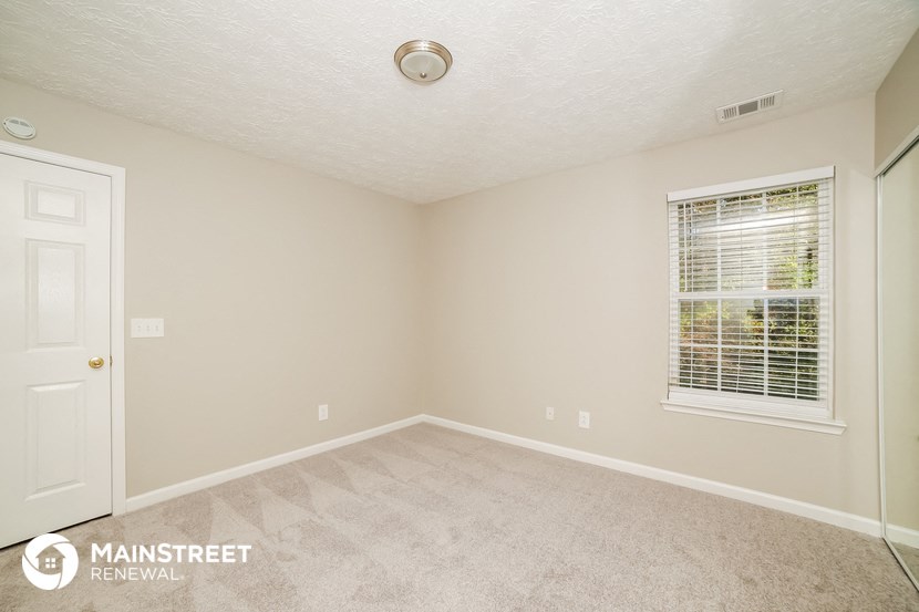 the spacious living room of a manufactured home with a white door and window
