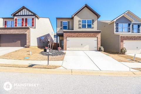 a house with two garage doors and a sidewalk in front of it