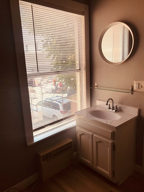 a bathroom with a window and a sink and a mirror