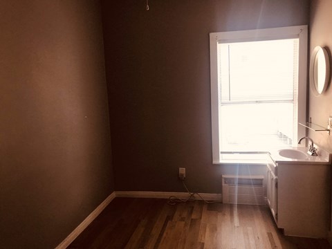 an empty room with a sink and a window