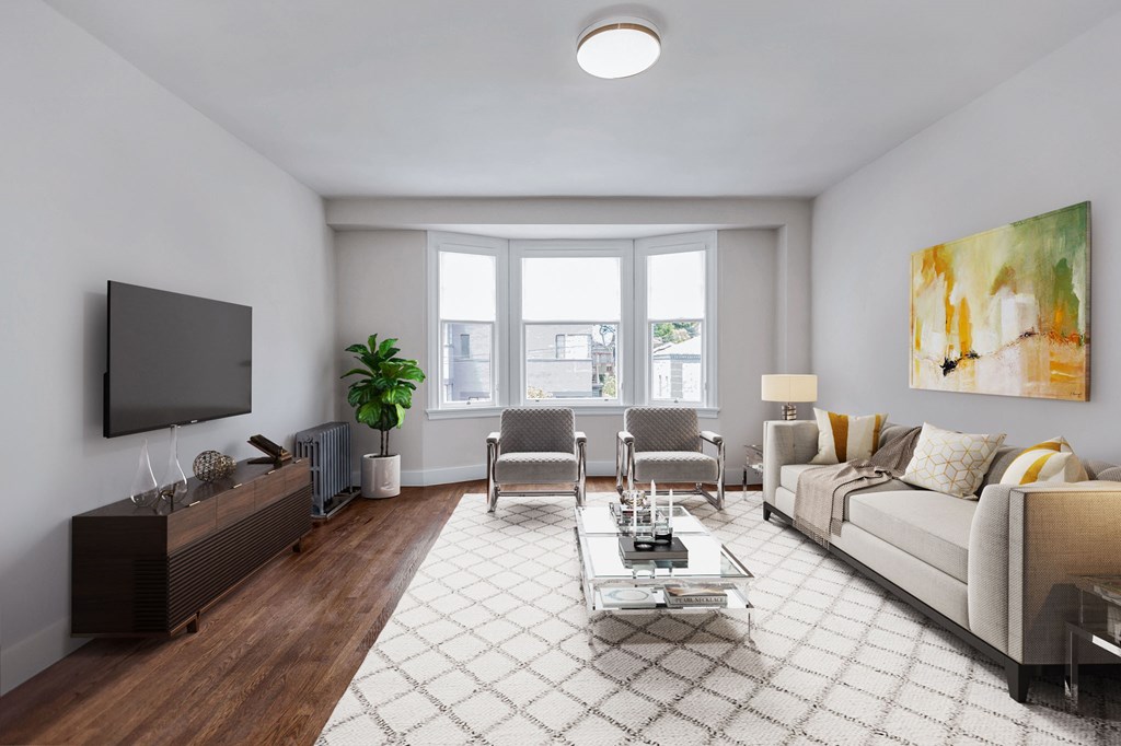 A living room with a couch, chairs, and a television.