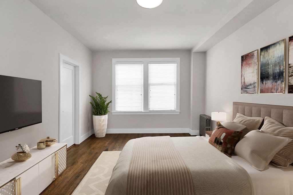 A bedroom with a large bed and a television on the wall.