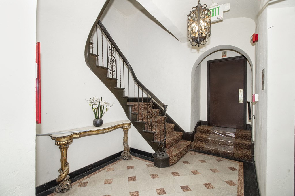 A staircase with a metal railing and a brown carpeted landing.