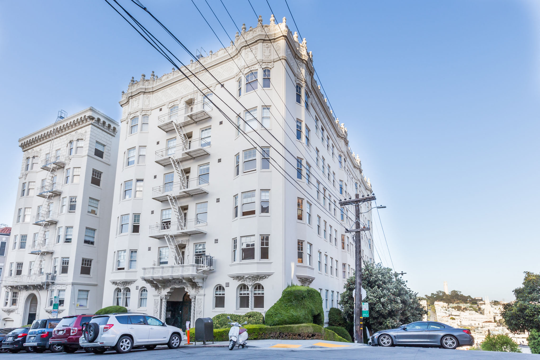 A large white building with a balcony on the second floor.