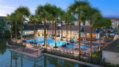 an aerial view of a resort with a pool and palm trees