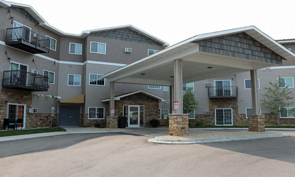 an apartment building with an awning and a driveway