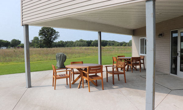 a patio with a table and chairs under a roof