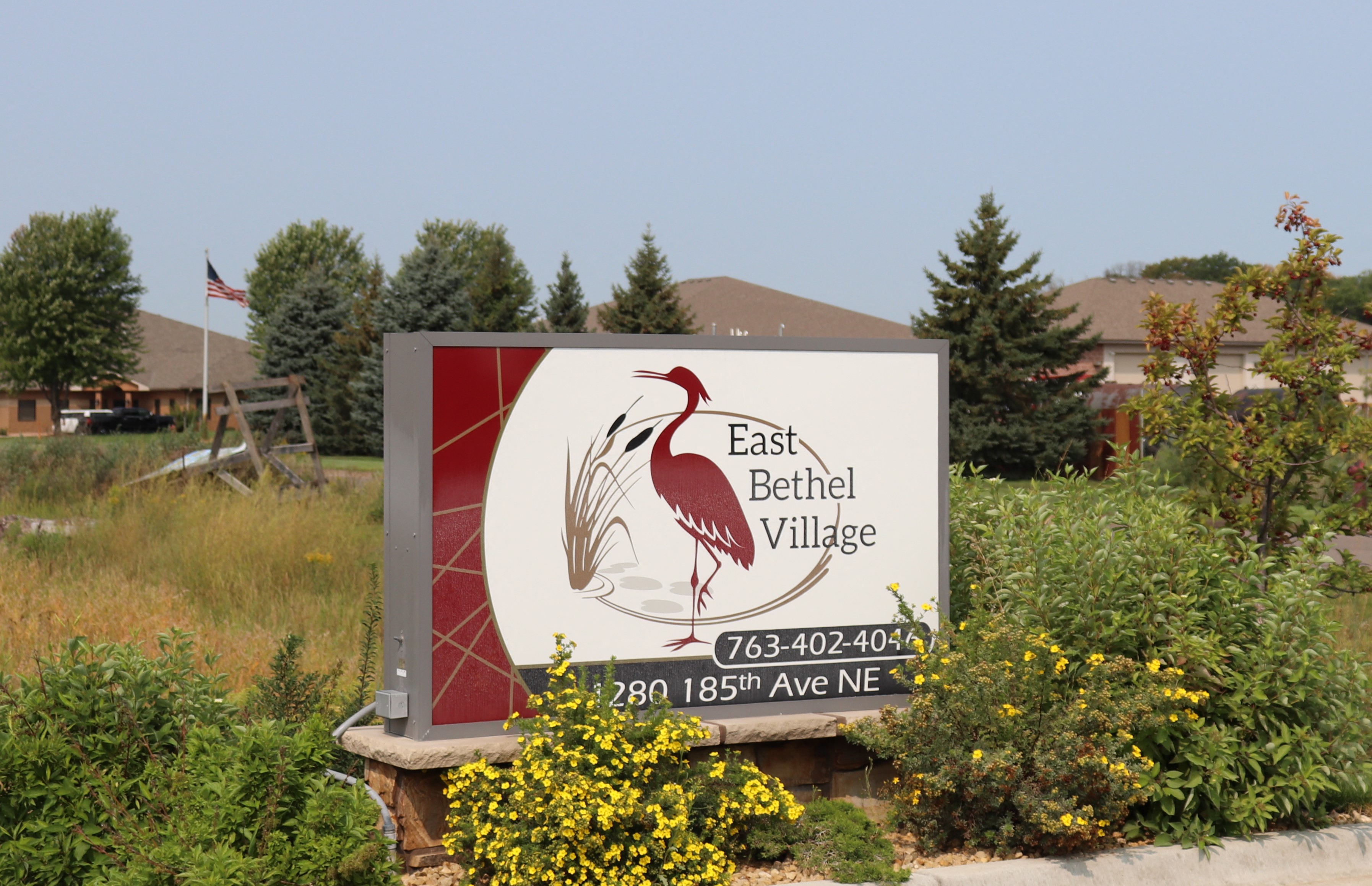 a sign village with a bird on it