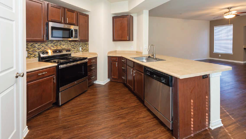 A kitchen with wooden cabinets and a white countertop.