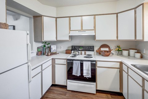 a kitchen with white cabinets and a stove and a refrigerator