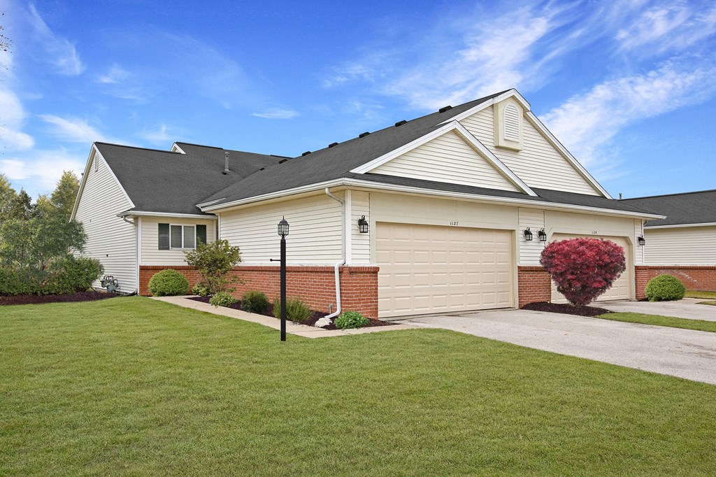 a white house with a yard and a driveway