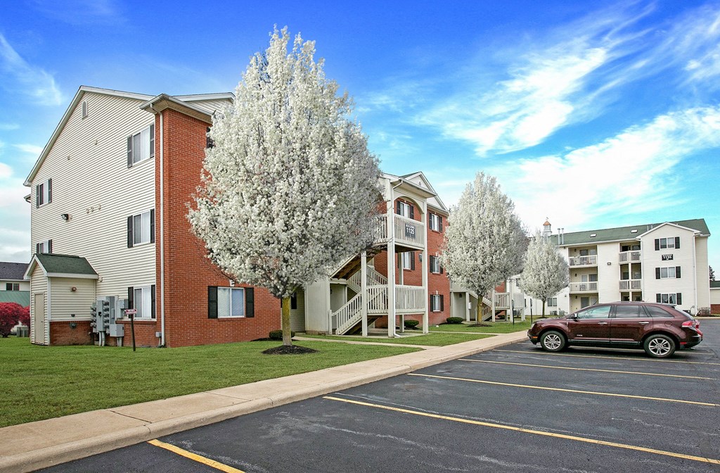 a red car parked in front of an apartment building