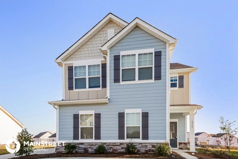a blue house with white siding and a blue sky