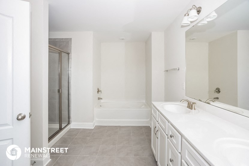a white bathroom with two sinks and a shower