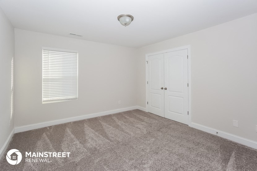 a bedroom with a carpeted floor and a white door