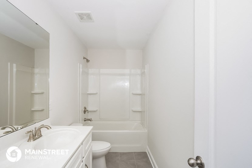 a white bathroom with a white toilet and a white tub and sink