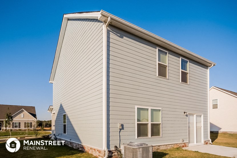 the exterior of a small house with a white siding