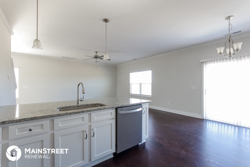 an empty kitchen with white cabinets and a counter top