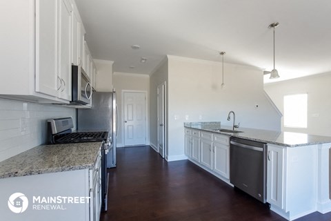 a renovated kitchen with white cabinets and granite counter tops
