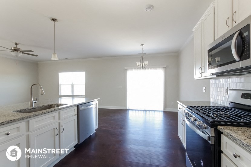 an empty kitchen with white cabinets and stainless steel appliances