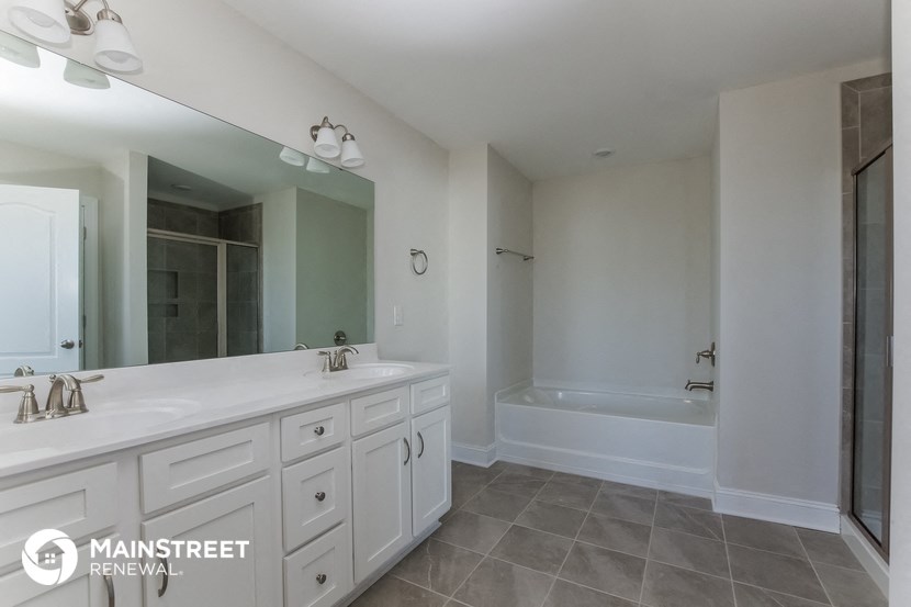 a white bathroom with a large mirror and two sinks