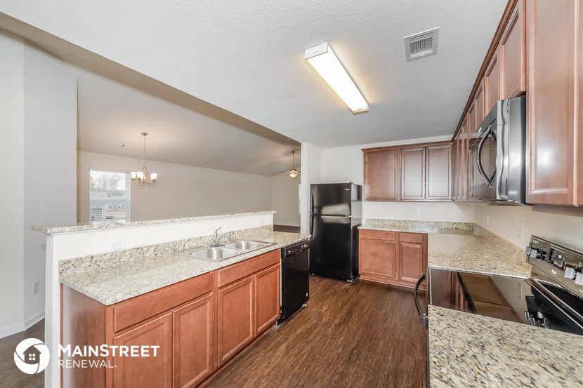 a kitchen with wood flooring and granite counter tops
