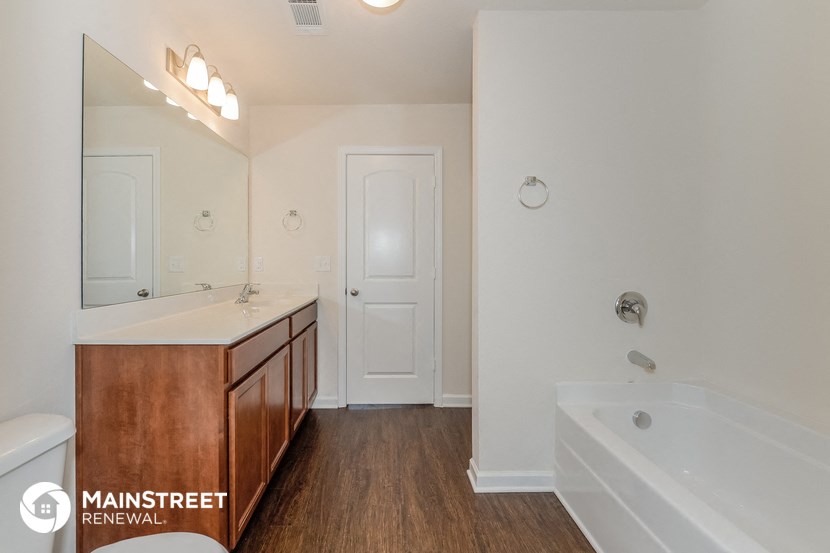 a bathroom with a tub and a sink and a mirror