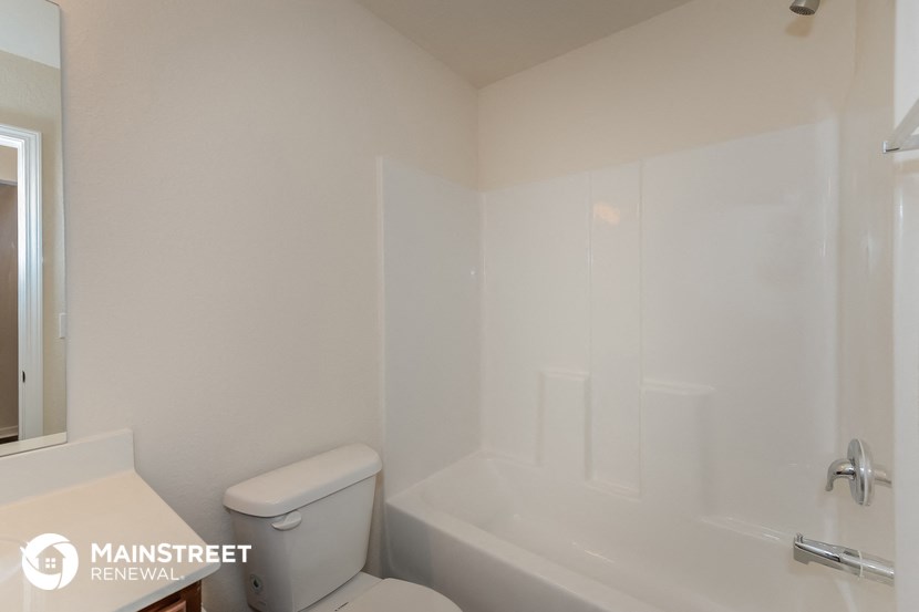 a bathroom with a toilet and a tub and a sink