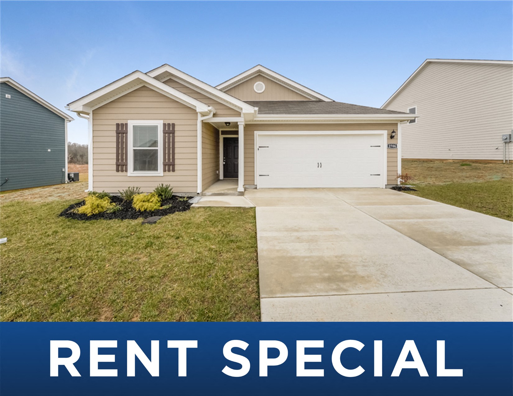a tan house with a yard and a driveway rent special