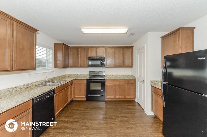 a kitchen with wooden cabinets and granite counter tops and black appliances