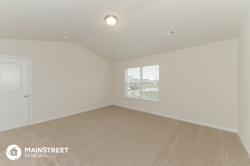 the living room of an apartment with white walls and a window