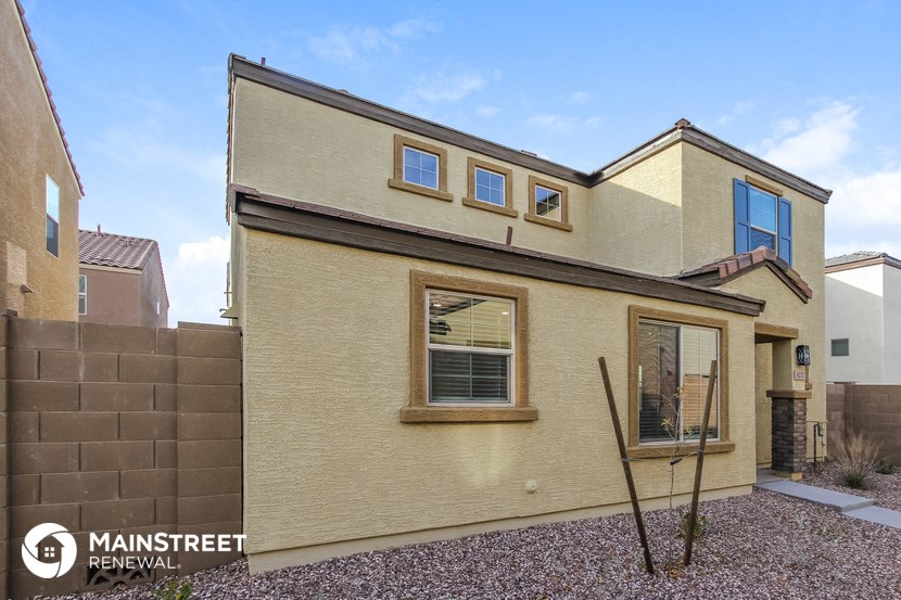 a yellow house with two windows on the side of it