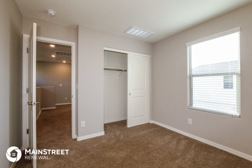a bedroom with a closet and a window and a door to a closet