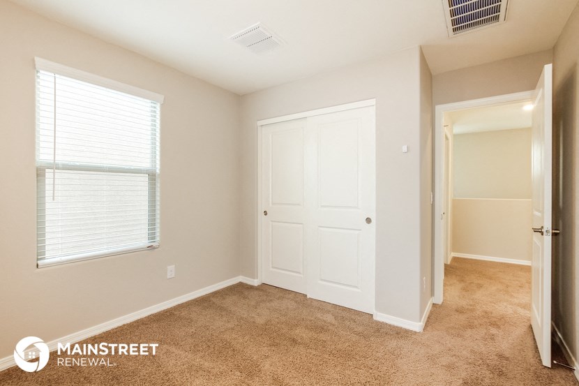 a bedroom with a door to a closet and a window