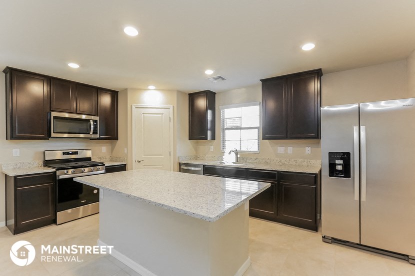 a kitchen with stainless steel appliances and a marble counter top