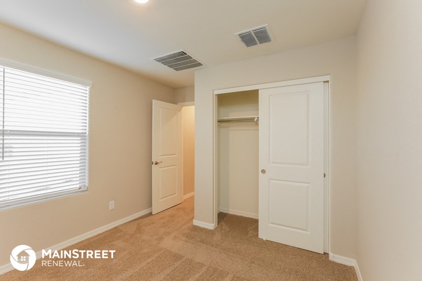 a bedroom with a closet and a window and an open door