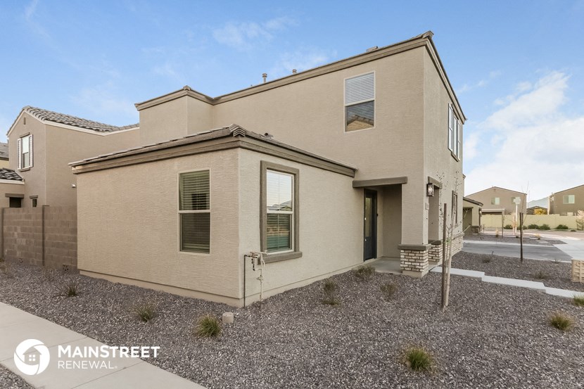 a beige house with a sidewalk in front of it